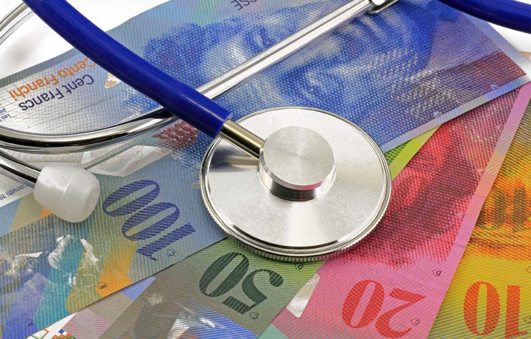 Gesundheitskosten: zwei Initiativen, keine Lösung. Im Bild ist ein Stethoskop und verschiedene Schweizer Franken Noten zu sehen.